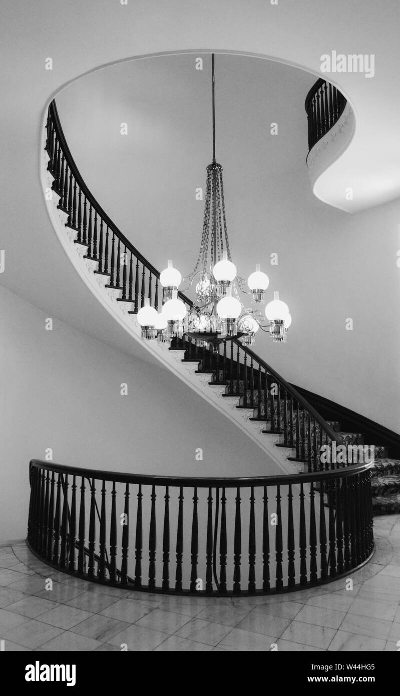 View of a Beautiful cantilevered spiral staircase with a chandlier inside the historic Alabama State Capitol building in Montgomery, AL, USA, in black Stock Photo