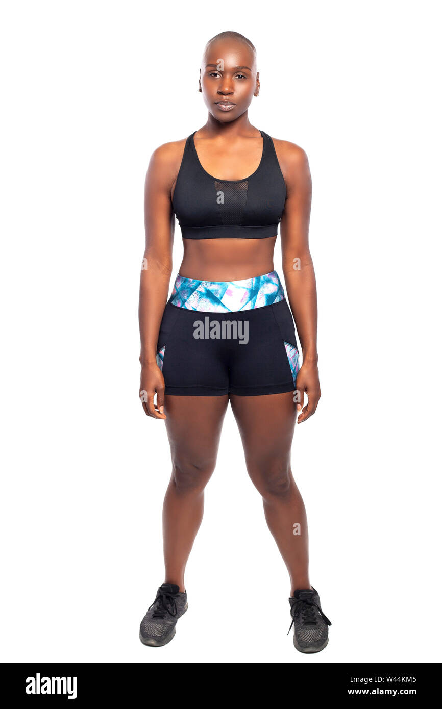 Athletic African American black female wearing workout clothing.  Her sporty outfit is a sports bra and form fitting spandex shorts.  She looks strong Stock Photo
