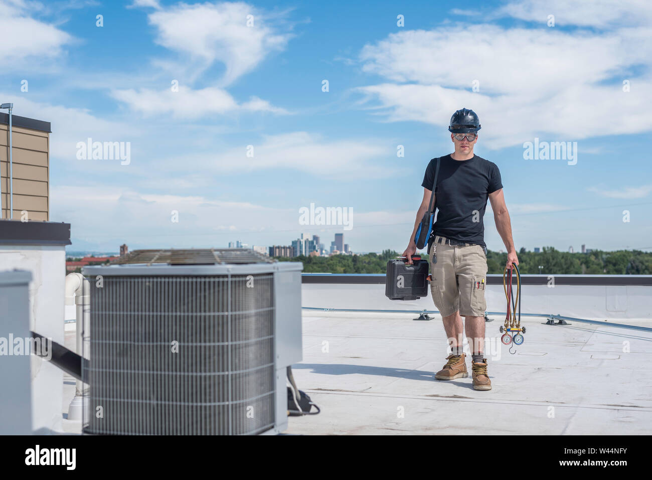 Hvac technician standing by an air conditioner condensing unit on a