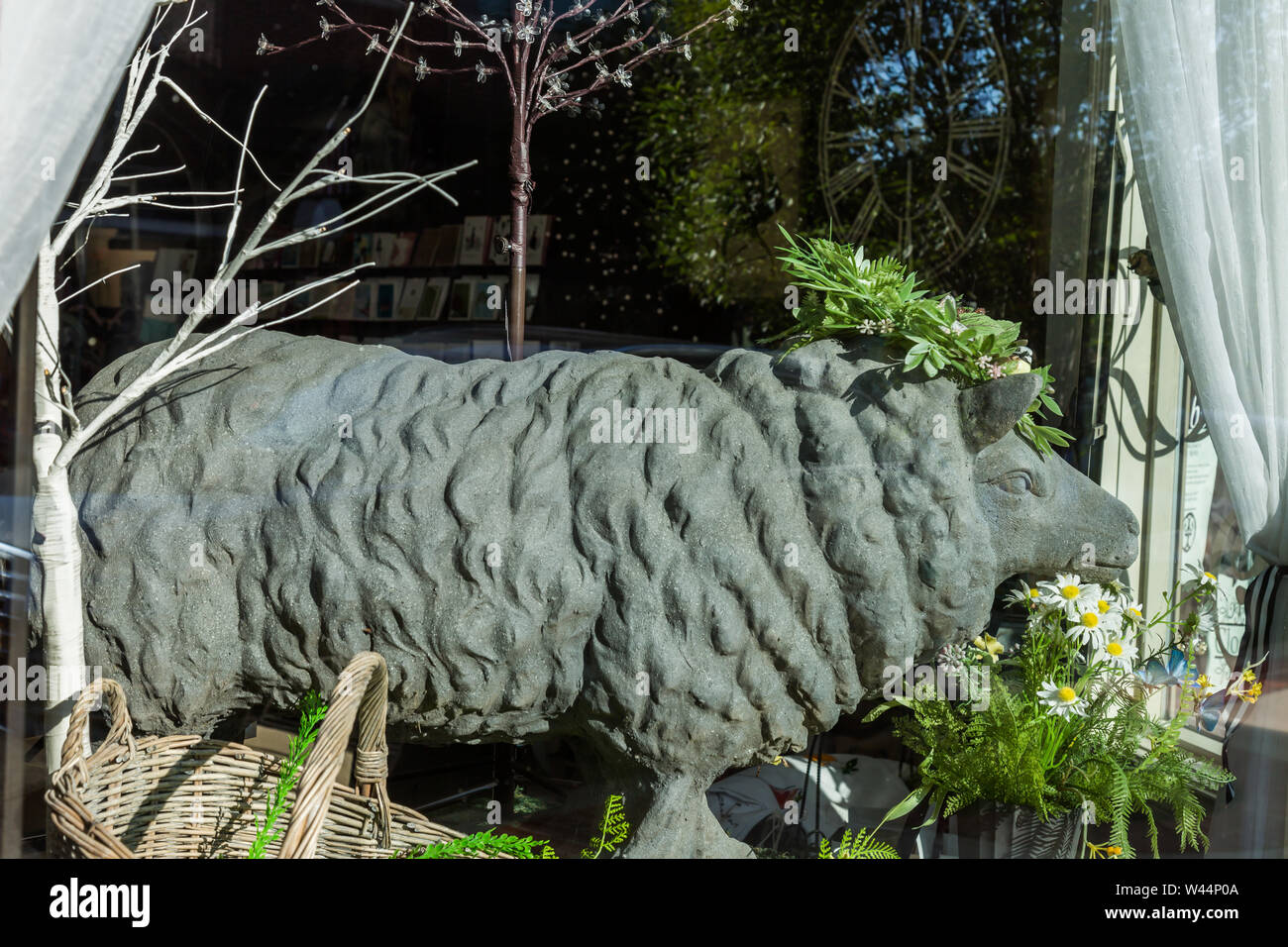 A concrete sheep statue stands in a store window in Roanoke, Indiana, USA. Stock Photo