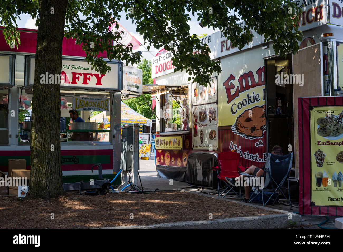 A worker takes a break beside the food vending trailer where he works