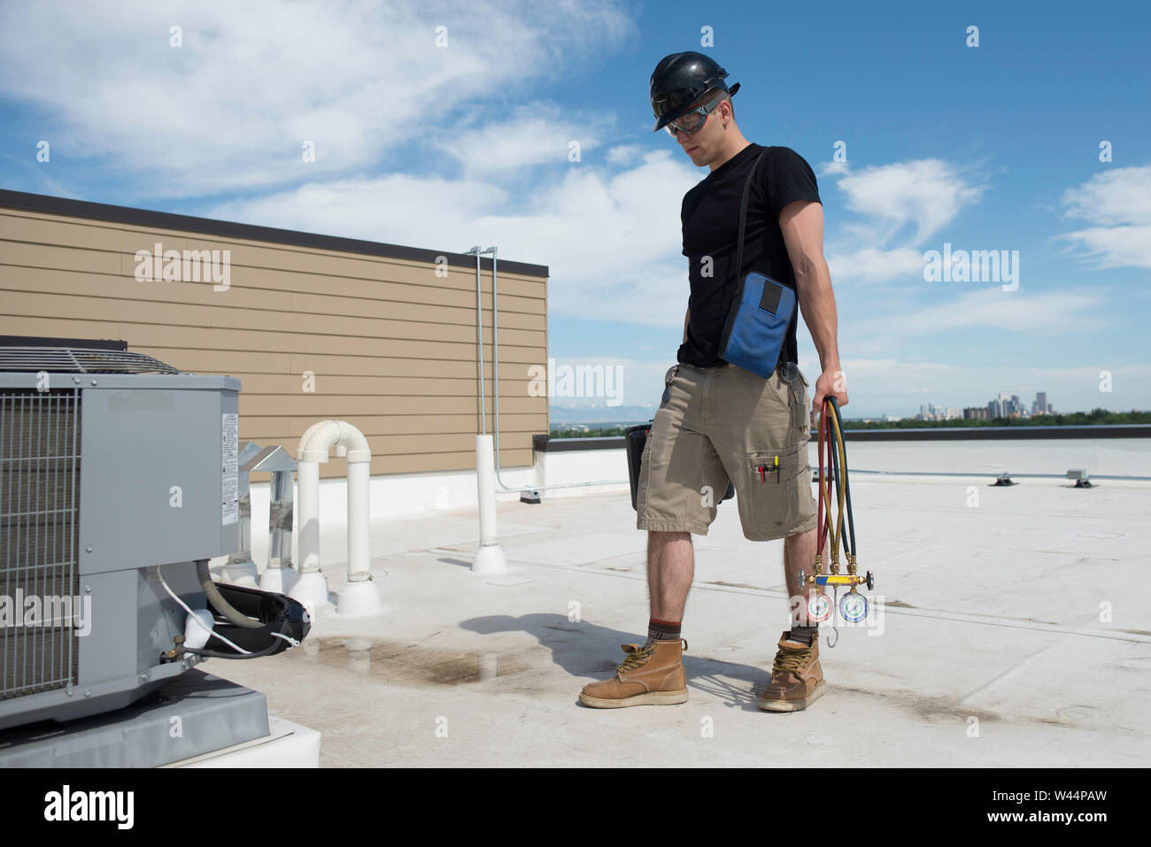Hvac tech walking up on a rooftop condenser that has a frozen suction