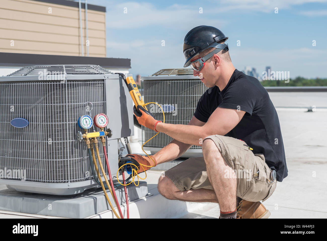 Hvac technician inspecting an condensing unit. Stock Photo