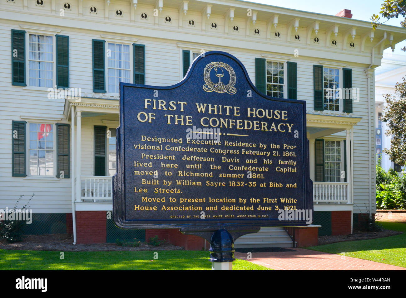 A blue metal sign with gold text in front of the First White House of the  Confederacy in Montgomery, AL, USA Stock Photo - Alamy