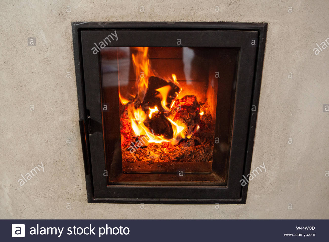 Hot Flaming Embers Are Viewed Through A Glass Door On A Burning