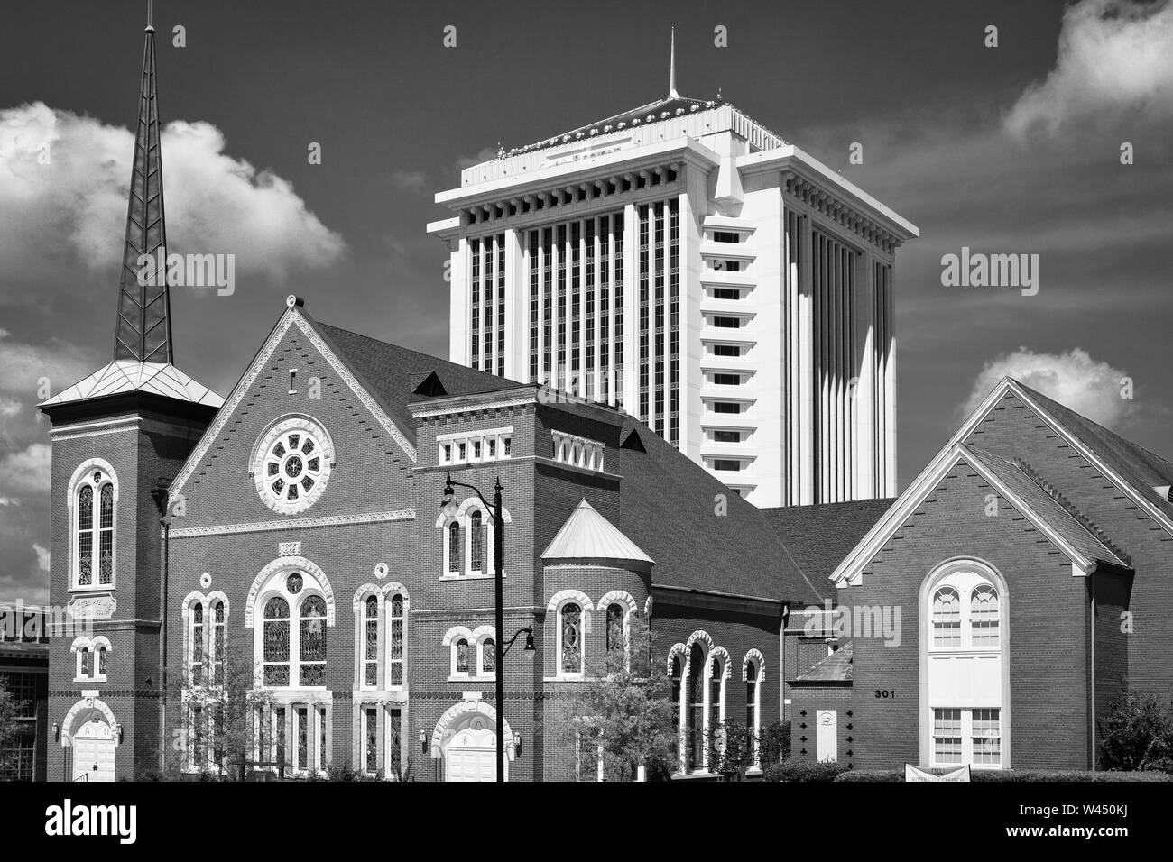 The River City Church, an historic Victorian structure with steeple stands before the RSA Tower, the tallest building in Montgomery, AL, black & white Stock Photo