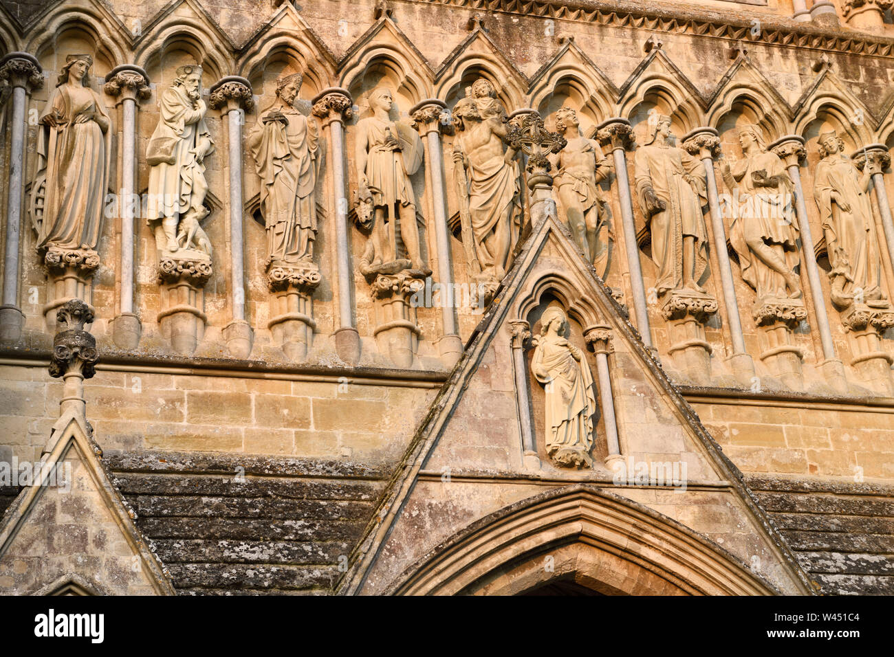 Detail of stone sculptures of Saints and Virgin Mary on Great West Front of 13th Century medieval Salisbury Cathedral England Stock Photo