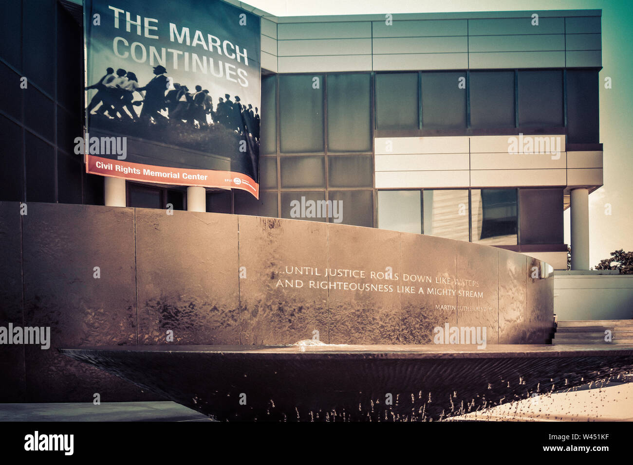 A photographic banner depicts African Americans on a protest march in front of the Civil Rights Memorial Center before the MLK Jr, quote and fountain Stock Photo