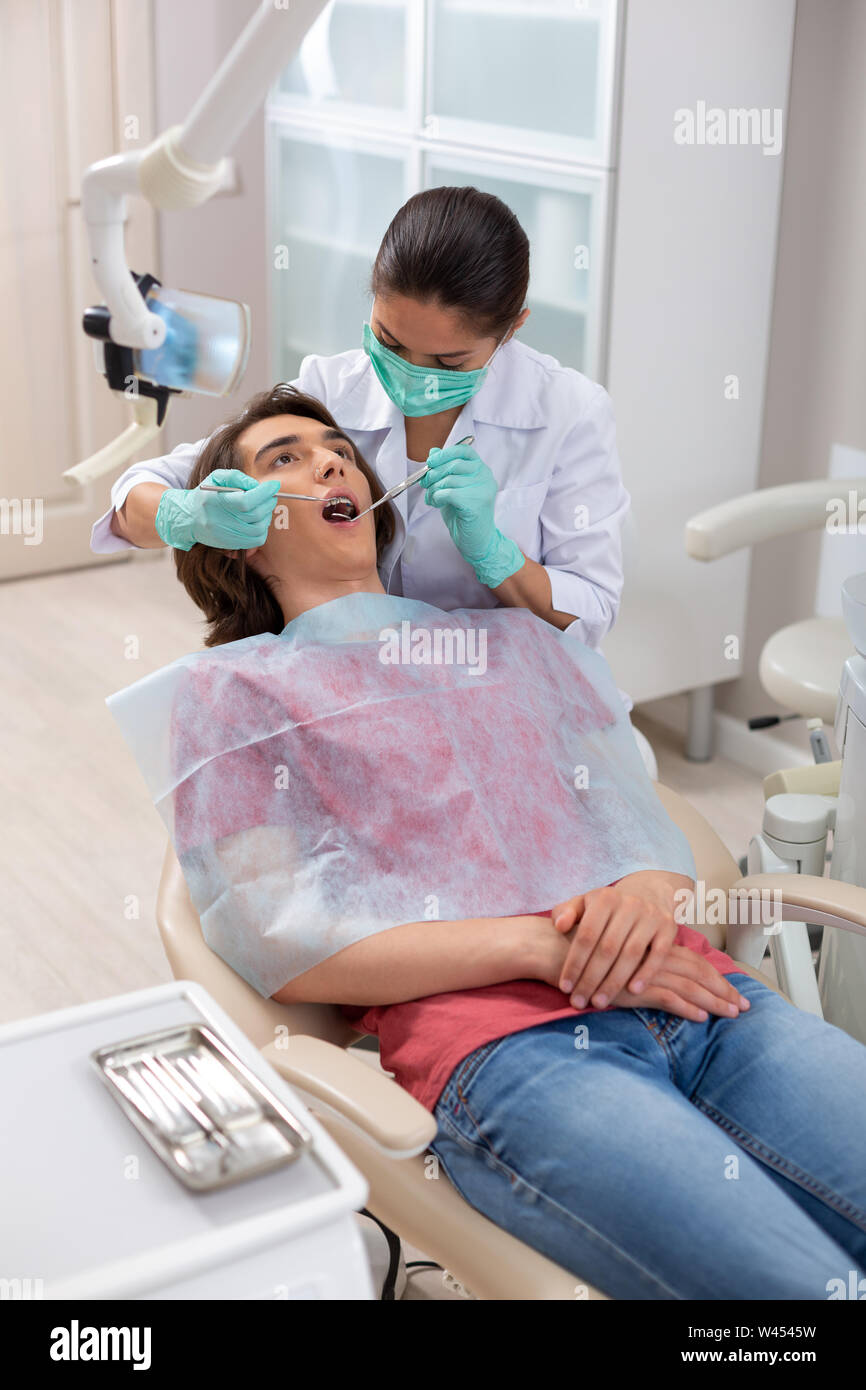 Dentist in green gloves performing a primary examination Stock Photo Alamy