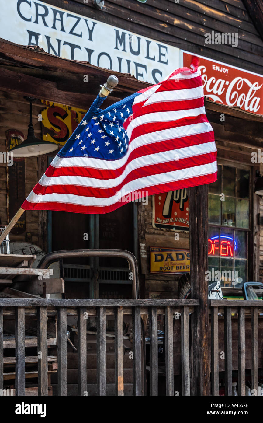 American flag waving from the front porch of Crazy Mule Antiques in Lula, Georgia. (USA) Stock Photo