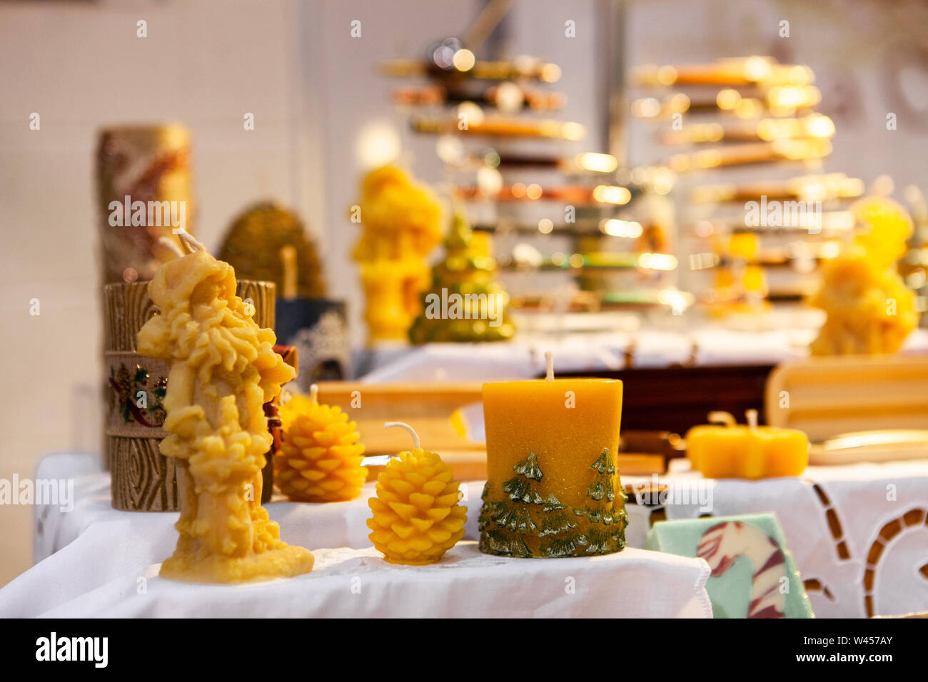 A close up view of hand sculpted wax candles on a stall during a local