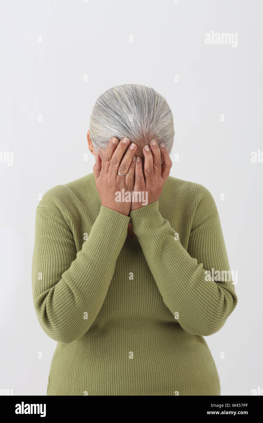 Woman covering her face with hands Stock Photo - Alamy