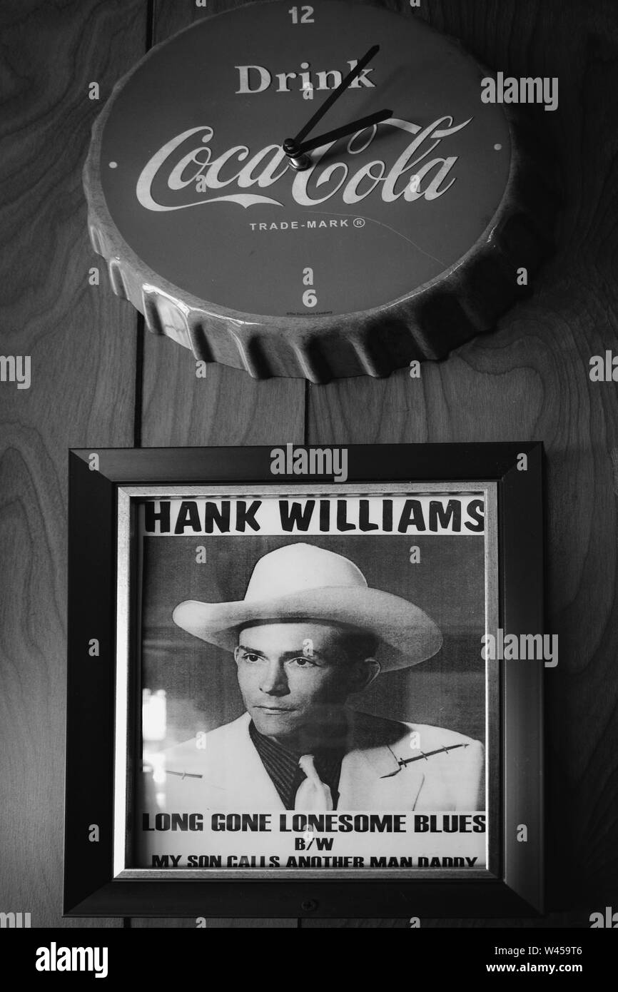 A vintage red Coca-Cola wall clock above a framed vintage photograph of Hank Williams, Sr, in Chris' Famous Hot dogs in Montgomery, AL,USA Stock Photo