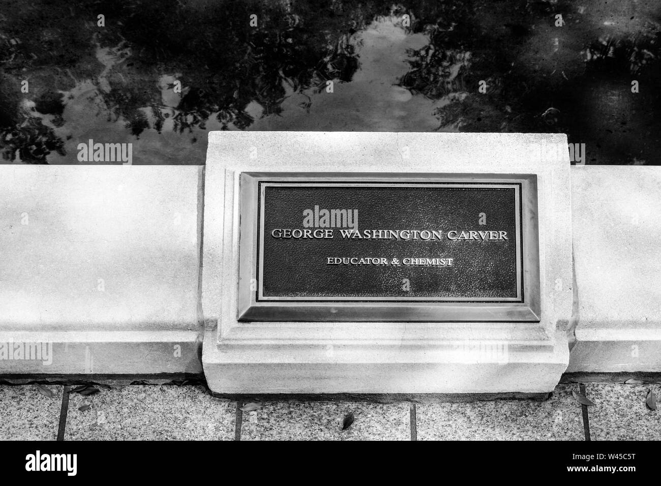 A bronze plaque commenorating George Washington Carver, Educator & Chemist, on the reflecting pool border on the RSA Tower Complex in Montgomery, AL,i Stock Photo