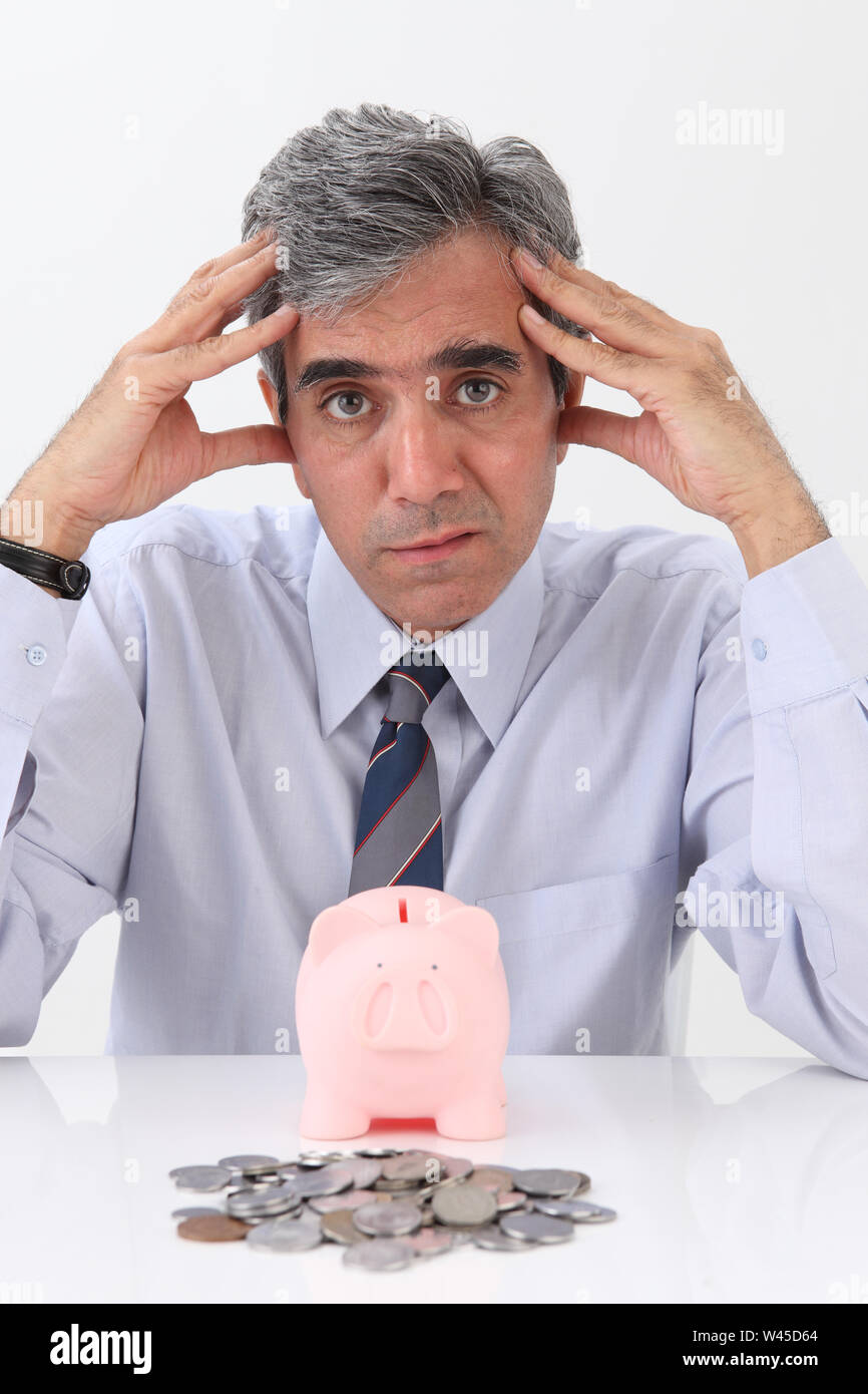 Portrait of a businessman looking depressed with piggy bank Stock Photo ...