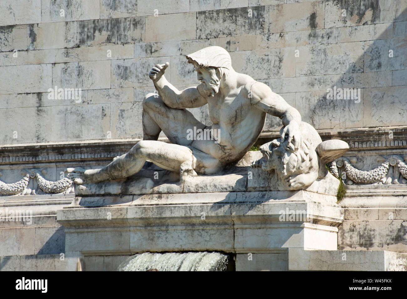 A statue of a strong reclining figure over an old building,  Florence's Accademia museum, Florence, Italy. Stock Photo