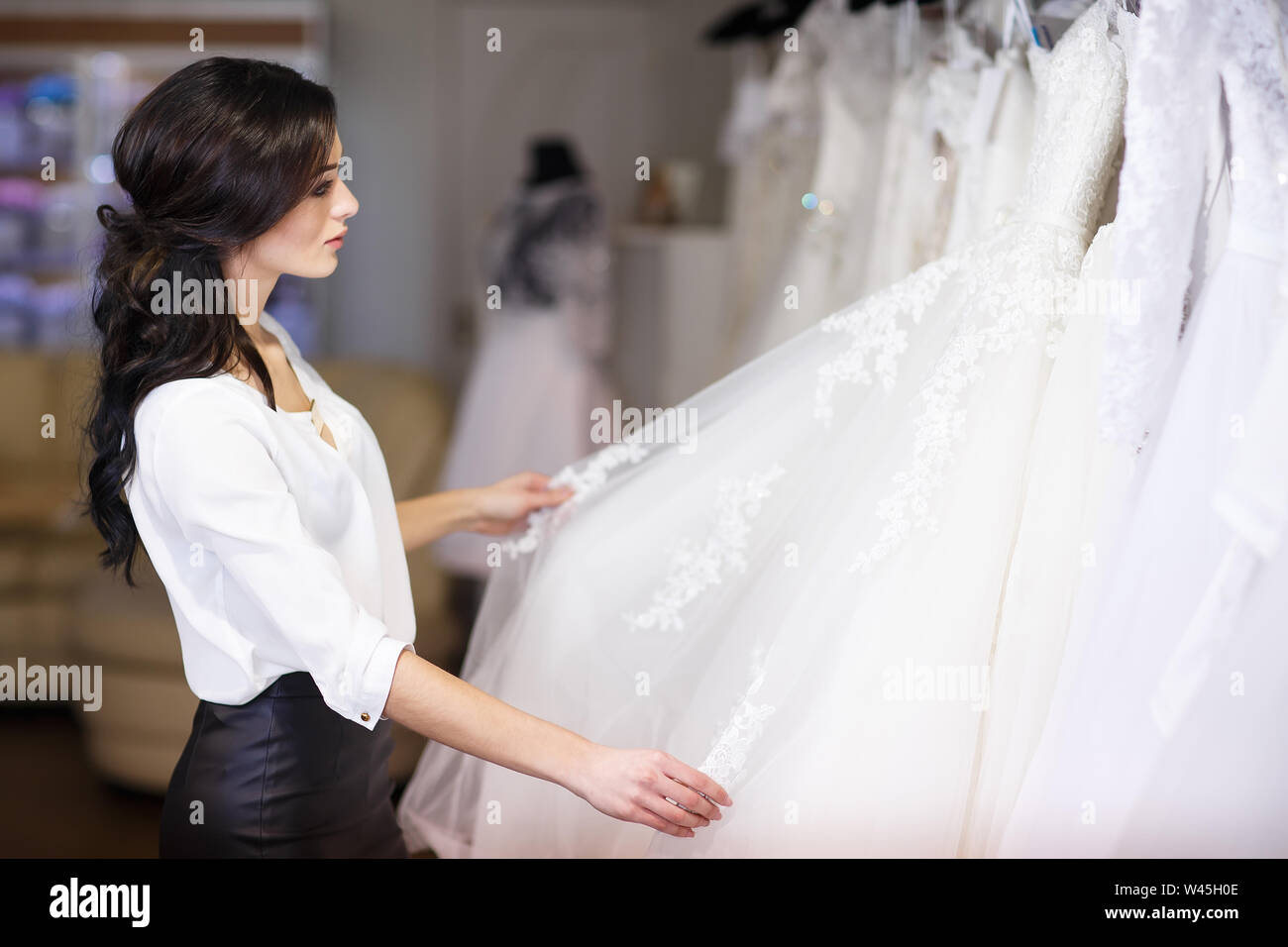 Dealer Consultant In The Background Of Wedding Dresses Stock Photo