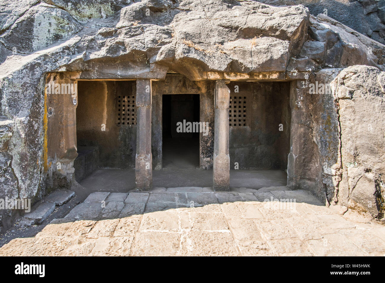 Cave 19, General view showing two simple slender pillars and perforated windows, Nasik, Maharashtra. Stock Photo