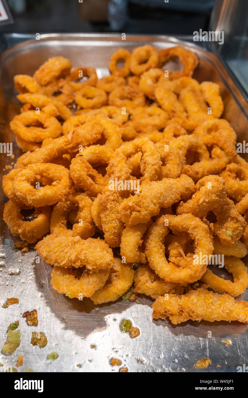 Deep fried batter squid rings on the tray for sale Stock Photo - Alamy
