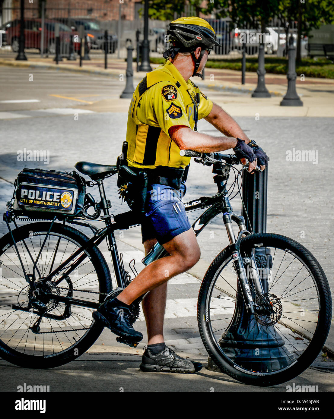 A bicycle policeman on duty rest with his bike on the streets of