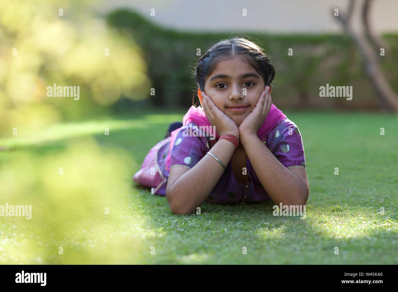 Portrait of a girl lying on lawn Stock Photo - Alamy