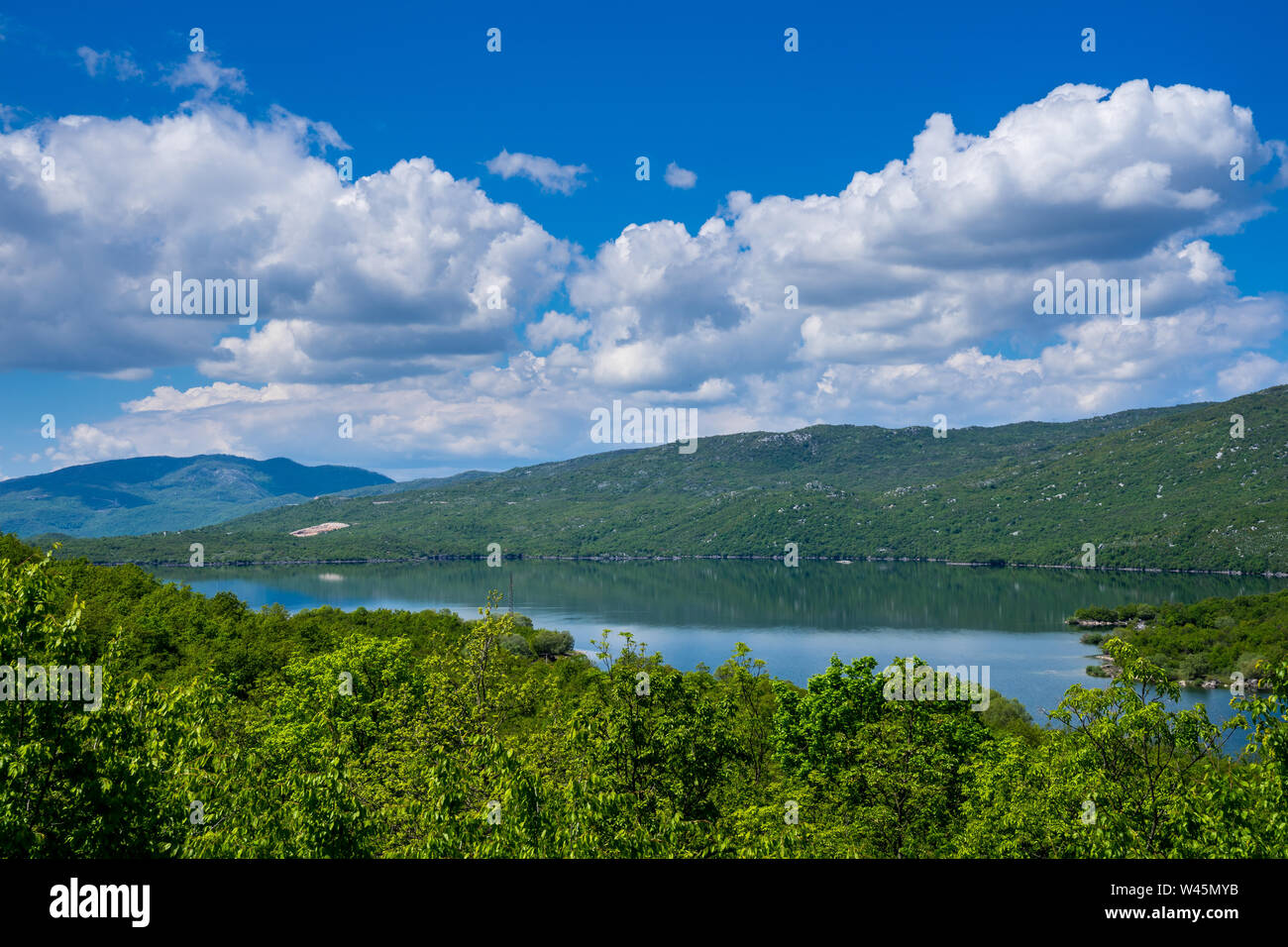 Montenegro, Lake krupac, a artificial lake next to niksic city surrounded by green trees and forest nature landscape reflecting in silent water with b Stock Photo