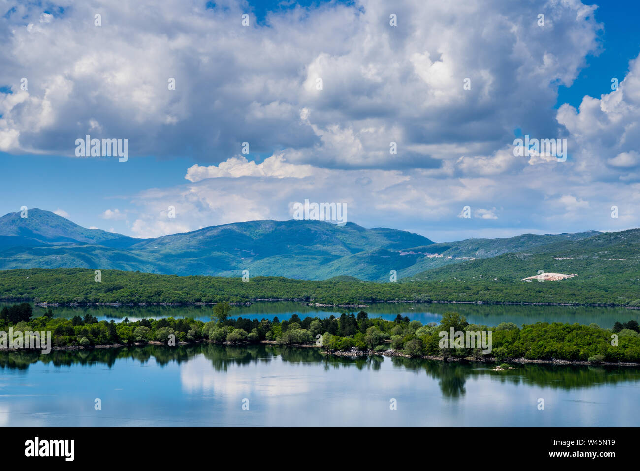 Montenegro, Glassy water of lake krupac, an artificial lake near niksic city inside green forest nature landscape surrounded by mountains under blue s Stock Photo