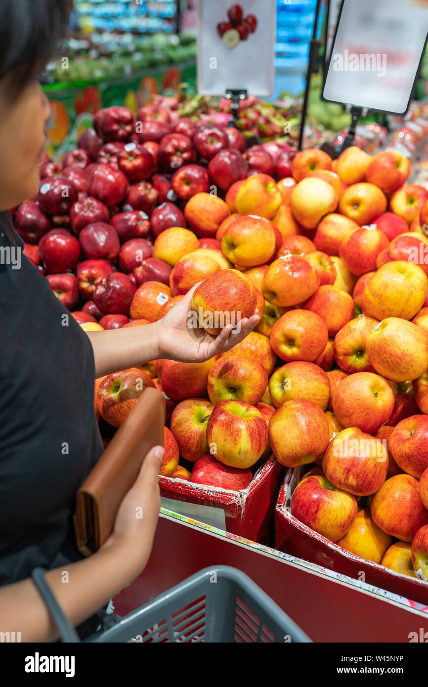 Asian woman picking an perfect apple at fruit store Stock Photo Alamy