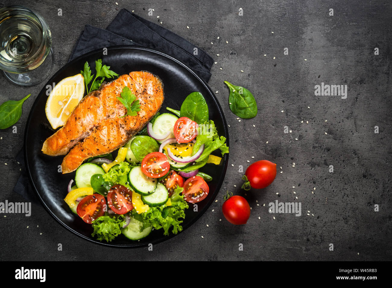 Grilled salmon fish steak with vegetables on black Stock Photo - Alamy