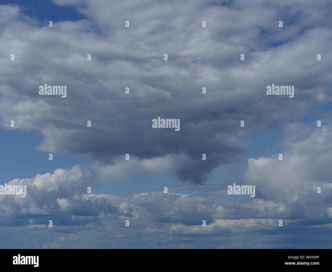 fluffy rain clouds in blue sky skyscape Stock Photo