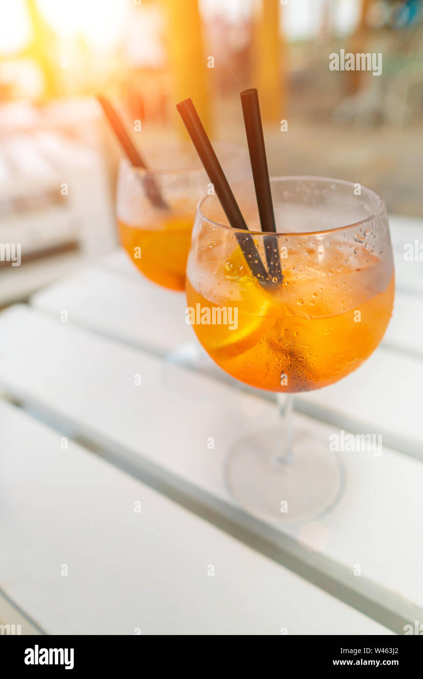 Delicious classic iced aperol spritz cocktail with ice cubes on a hot tropical beach in summer sunshine Stock Photo