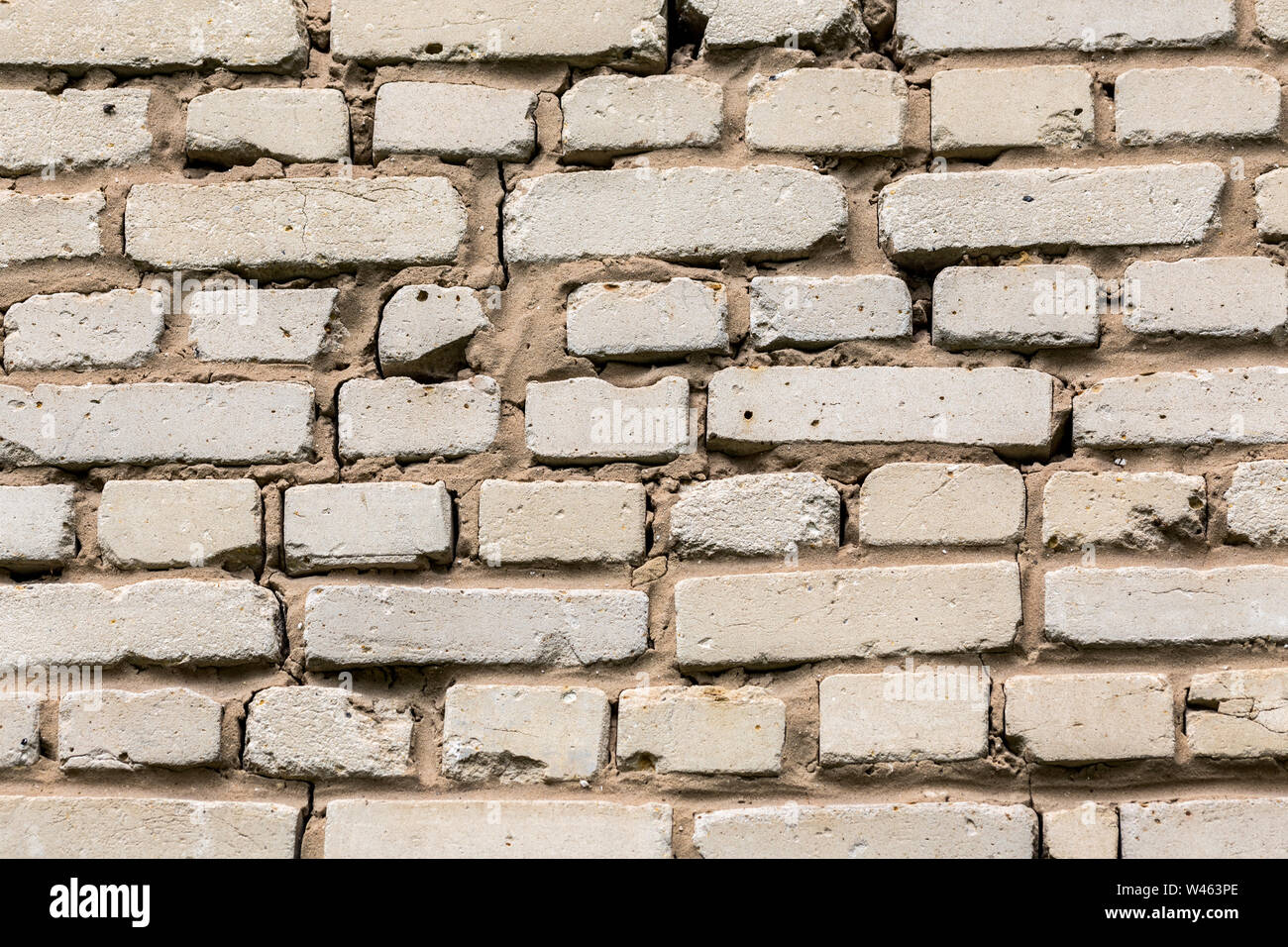 Deep cracked white silicate brick wall closeup texture and background. Horizontal shot. Stock Photo