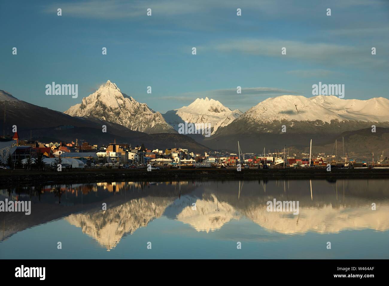 City view with reflection in the water, behind snow-covered Andes with Monte Olivia, Ushuaia, Tierra del Fuego, Argentina Stock Photo