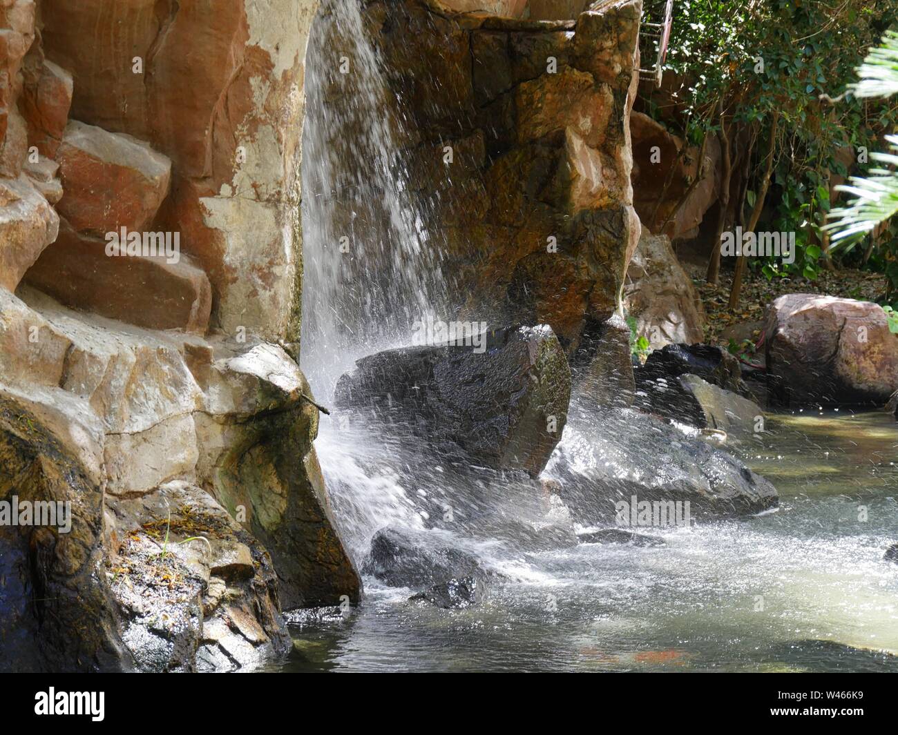 Waterfall Rocks Side View Side view of water cascading down rocks in a landscaped garden Stock ...
