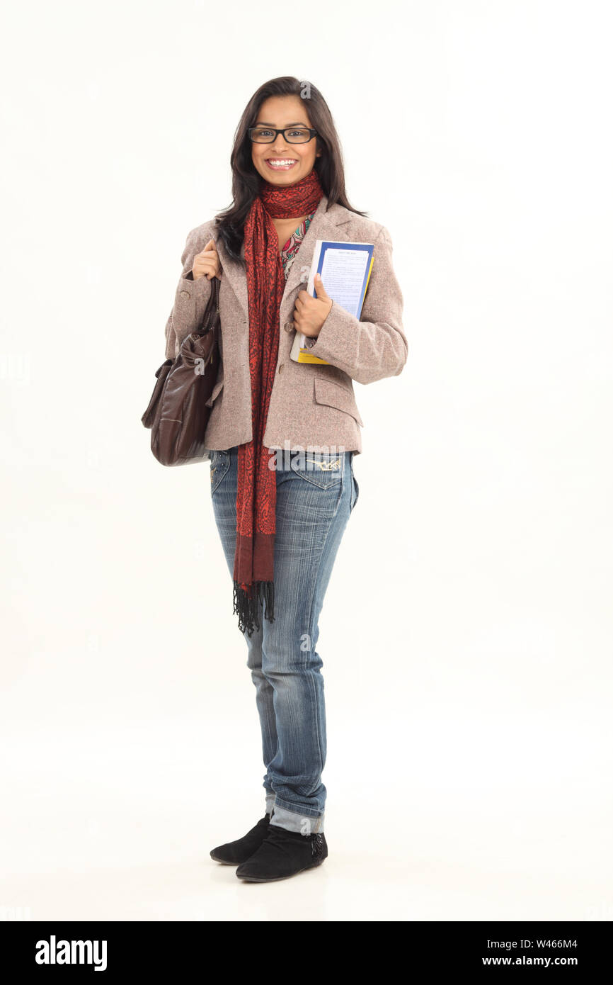 College student holding books and smiling Stock Photo - Alamy