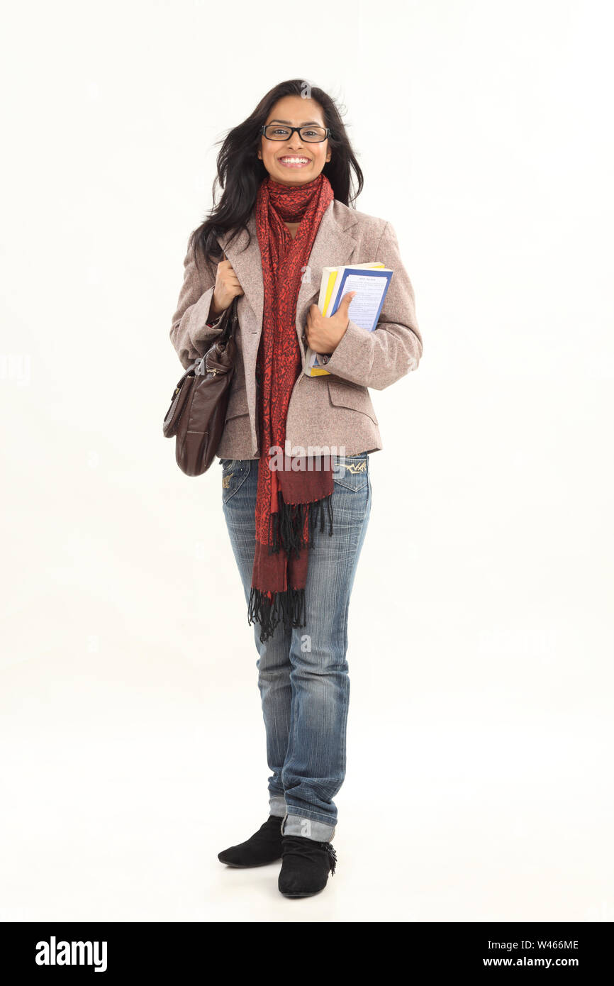 College student holding books and smiling Stock Photo - Alamy