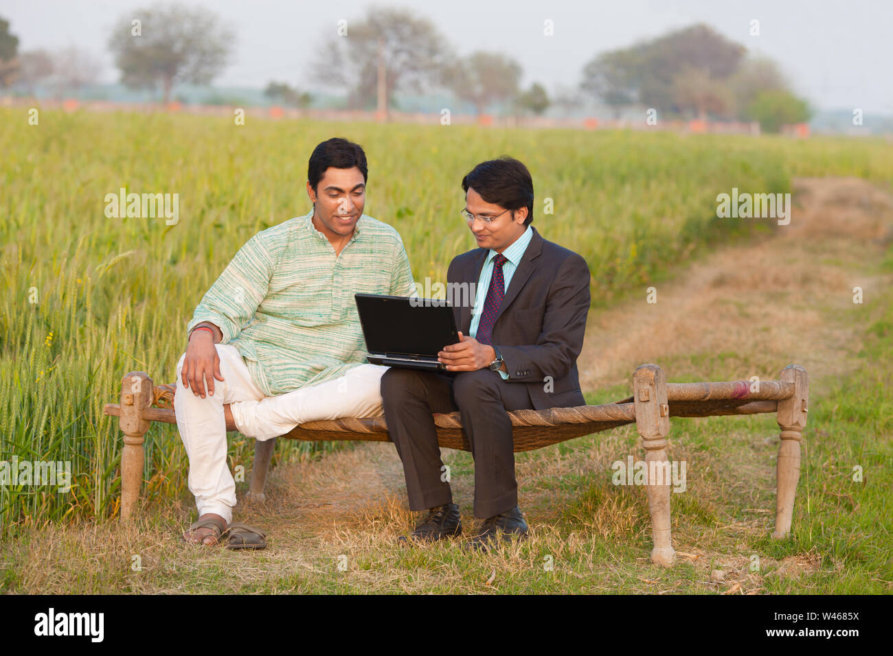 Advisor working on a laptop with a farmer Stock Photo