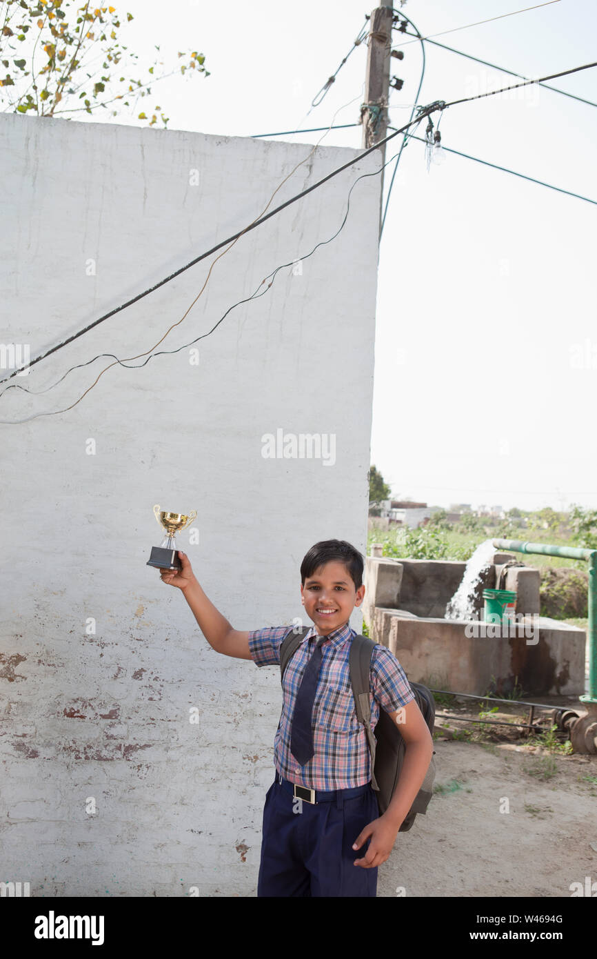 Portrait of a schoolboy holding a trophy Stock Photo