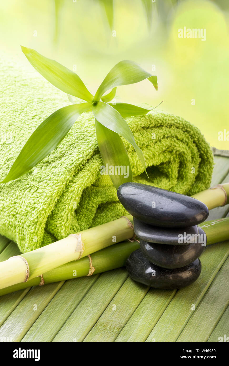 closeup with black stones for massage therapy, some bamboo stalks with ...