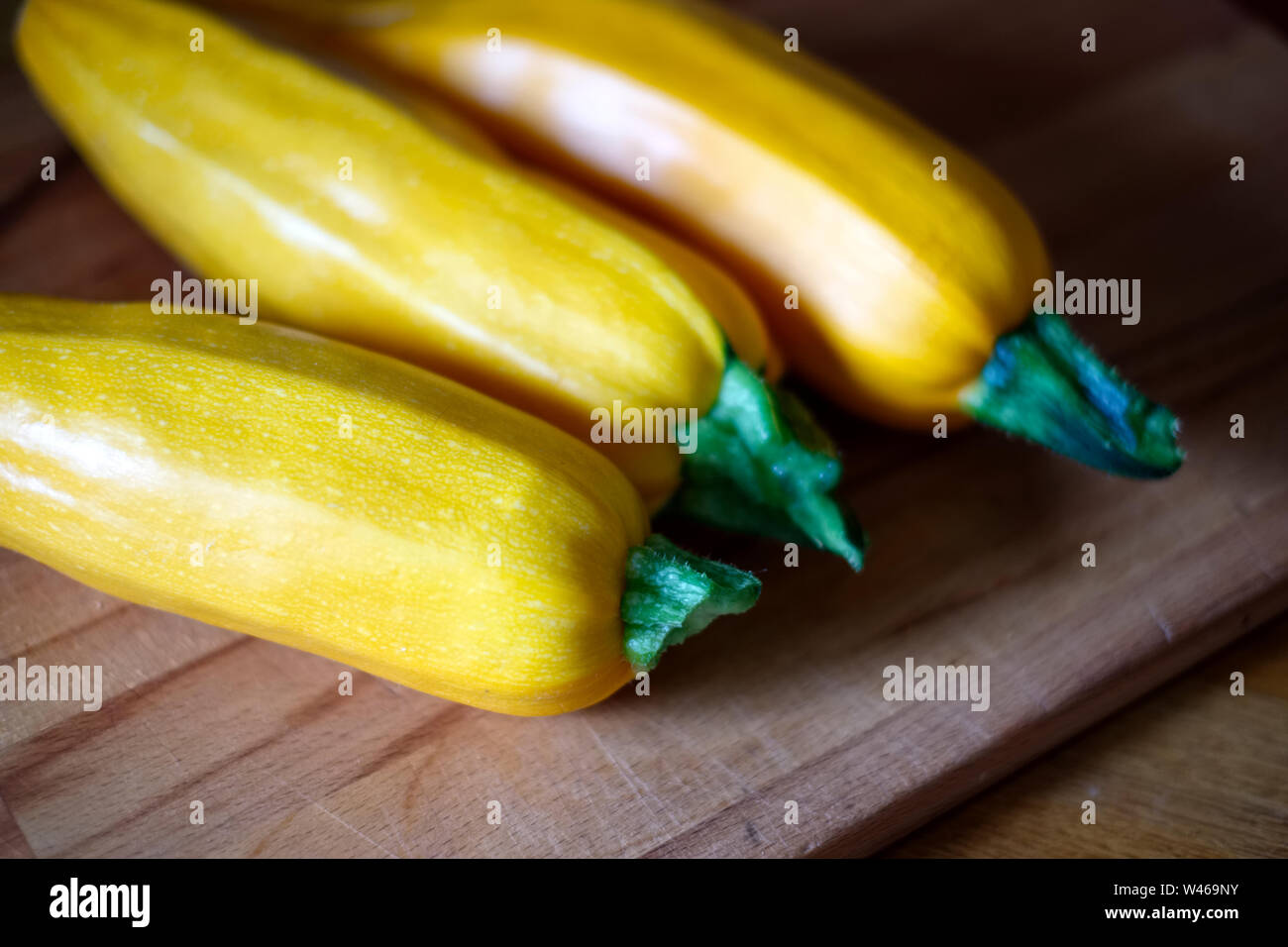 Yellow courgettes on a wooden board Stock Photo