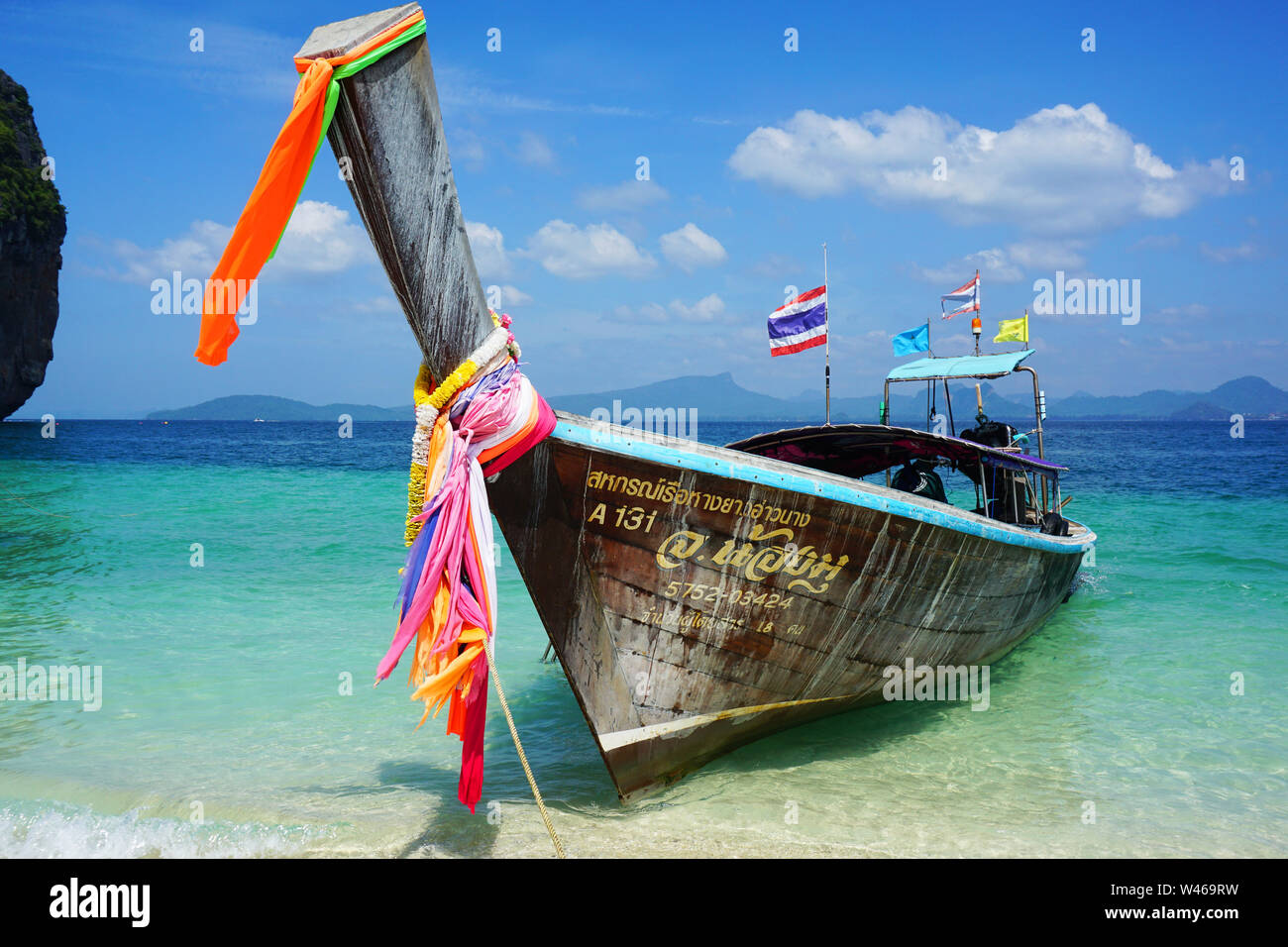 Thailand's traditional long-tail boat docked at a beach in Phi Phi Islands. This boat is colorful with a distinct appearance brings tourists around Stock Photo