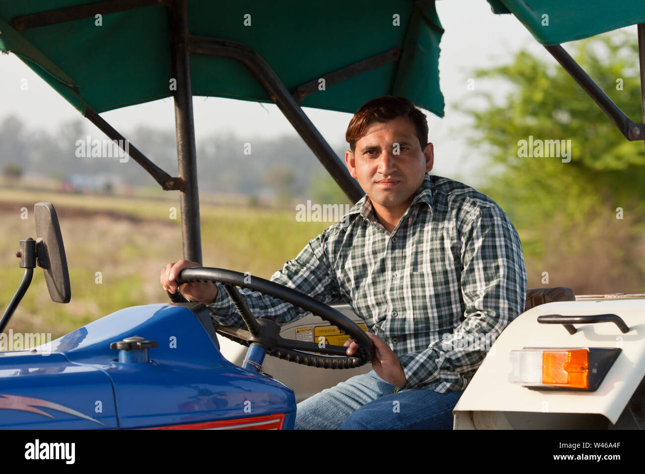 Portrait of a farmer driving a tractor Stock Photo - Alamy