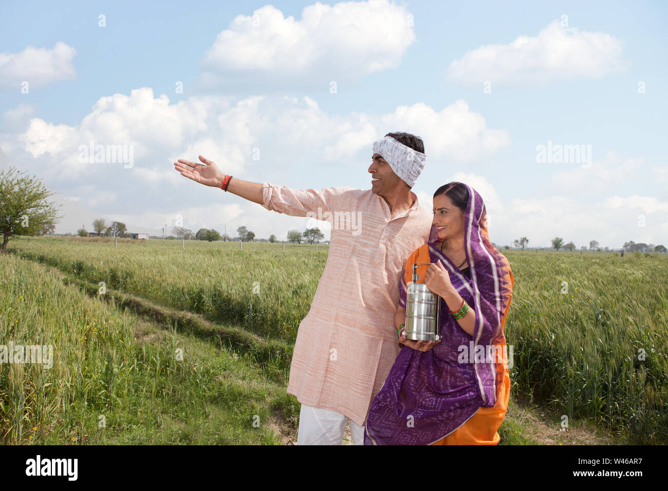 Farmer showing his field to his wife Stock Photo - Alamy