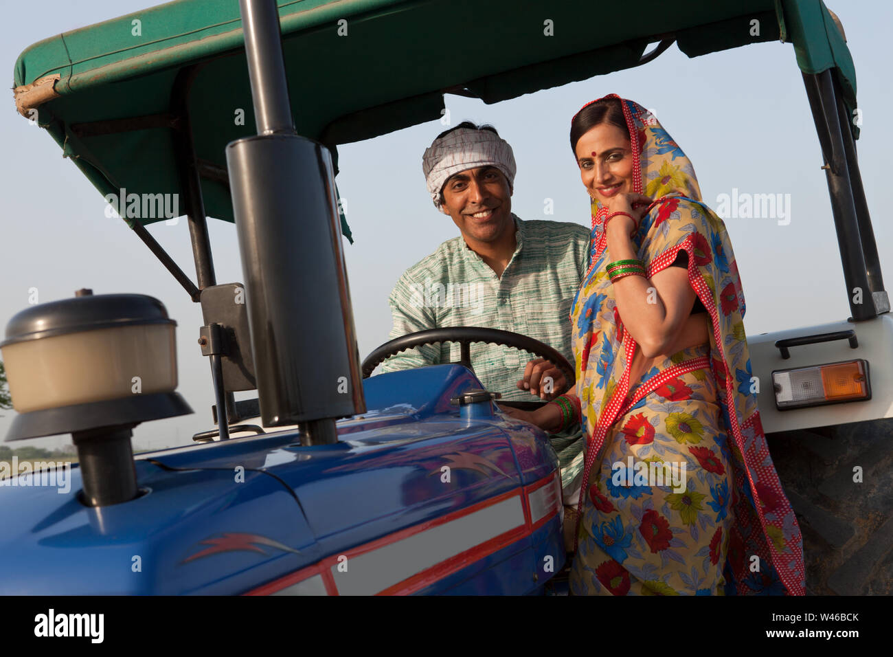 Portrait of a farmer with his wife smiling in a tractor Stock Photo - Alamy