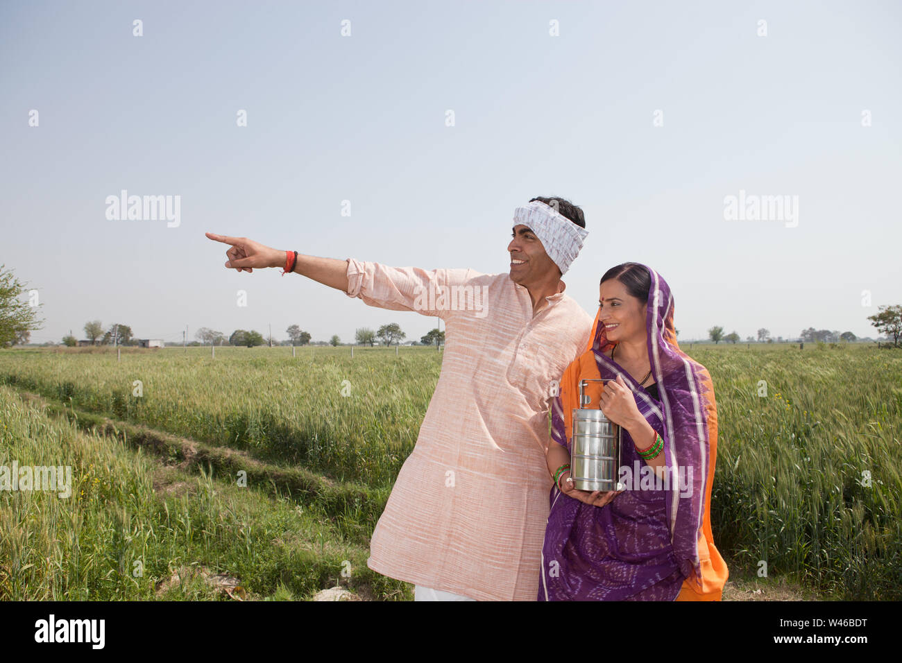 Farmer showing his field to his wife Stock Photo - Alamy