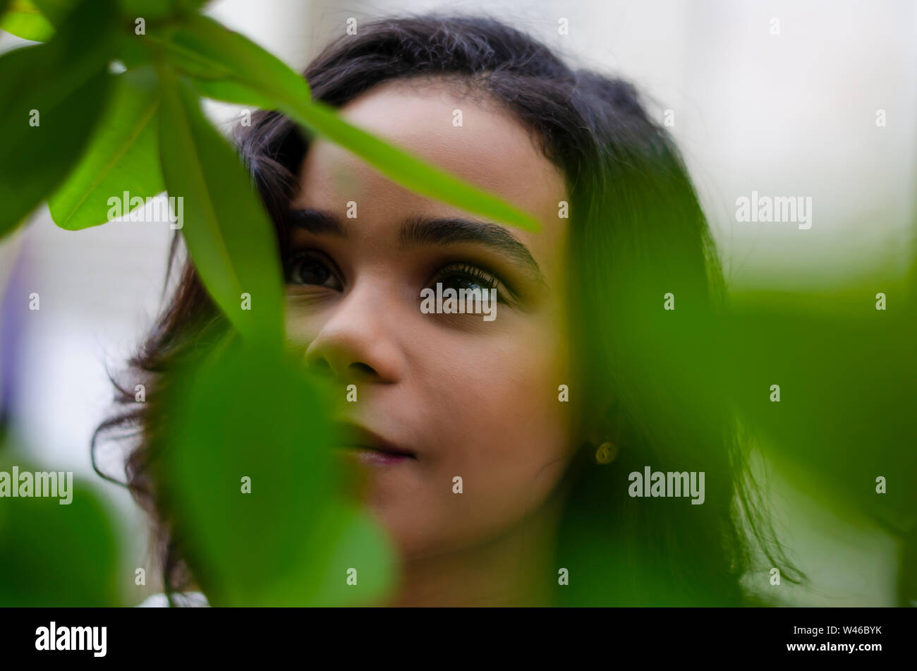 Young girl from 19 to 25 years old looking at the plants and enjoying the natural on a summer day lifestyle on her vacations Stock Photo