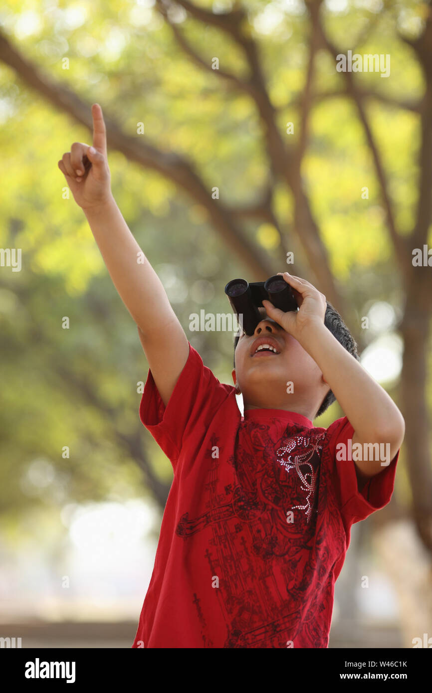 Boy looking through binoculars Stock Photo