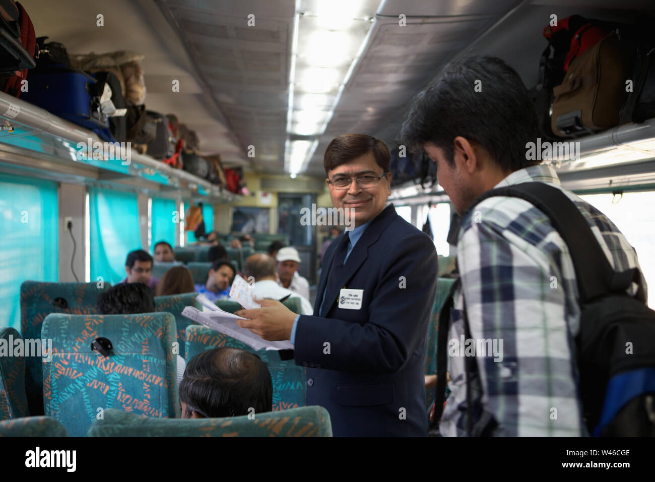 Ticket collector checking tickets in a train Stock Photo