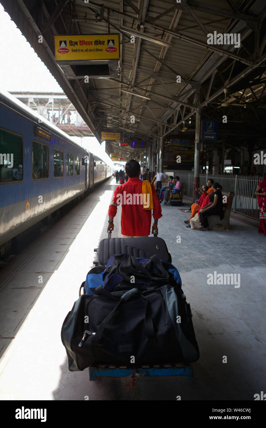 Coolie pulling luggage cart at a platform Stock Photo Alamy
