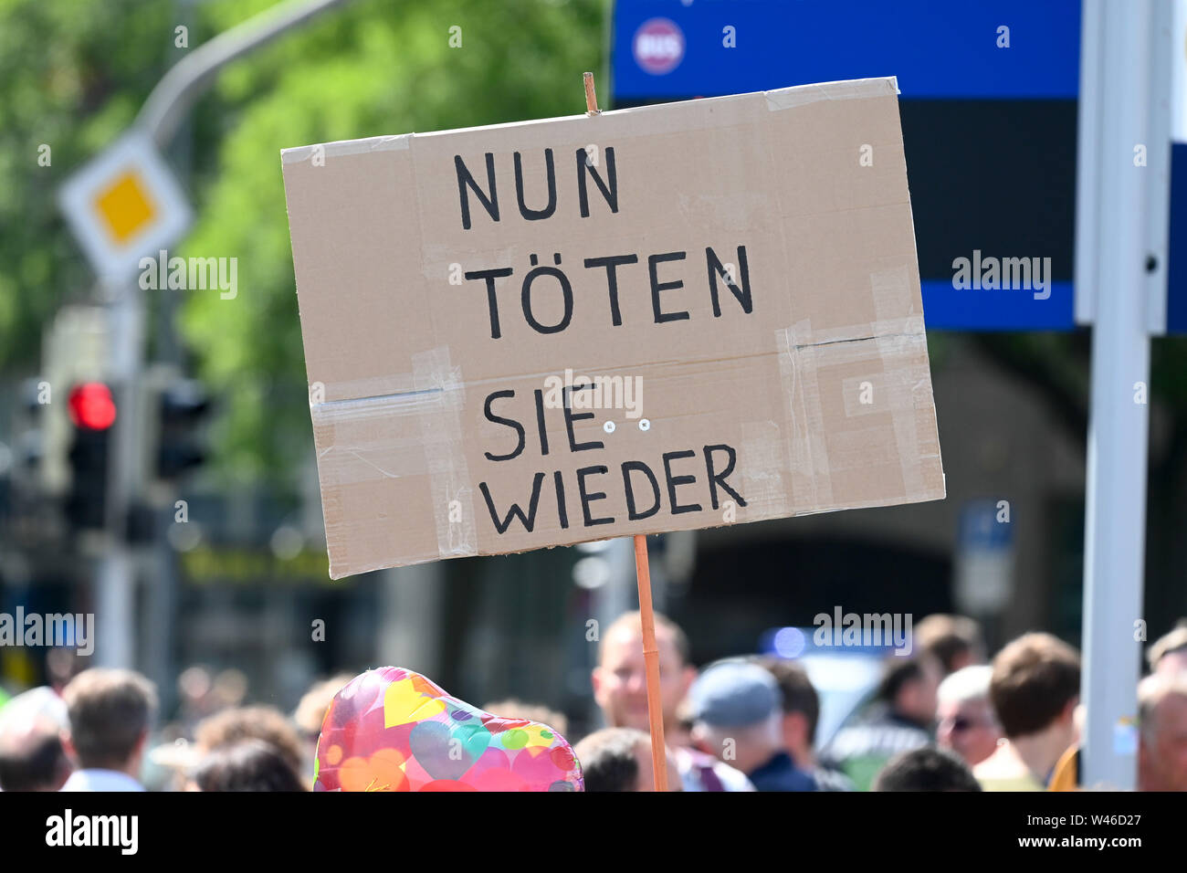 Kassel, Germany. 20th July, 2019. A demonstrator against the march of the smallest party 'The Right' holds up a poster with the inscription 'Now they kill again'. The party had called for a demonstration in Kassel against media prejudgement in connection with the Lübcke case. A massive police presence is to prevent possible riots between the two camps. Credit: Uwe Zucchi/dpa/Alamy Live News Stock Photo